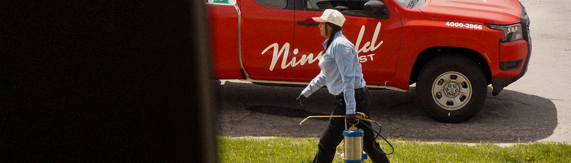 female pest technician walking to a home - residential pest control